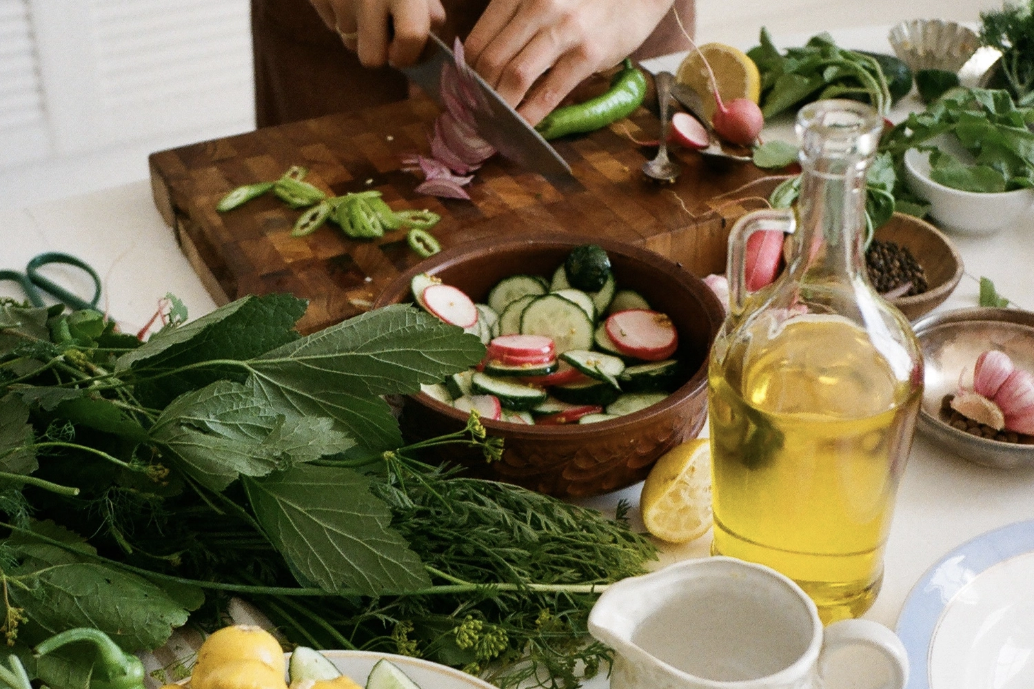 person chopping a variety of vegetables